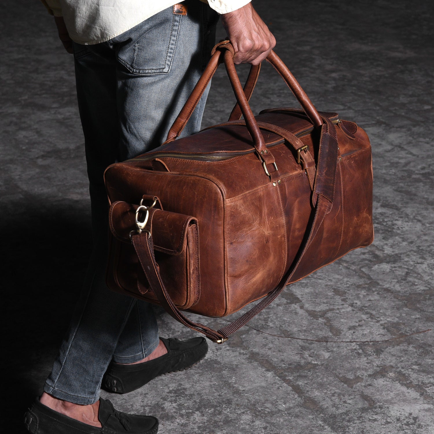 man-walking-with-a-leather-travel-bag